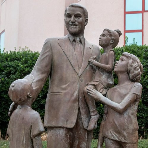 Statue of man with kids from Perge Carpet & Floors in Wheaton, MD